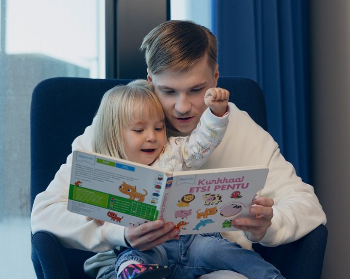 Lastenhoitaja lukee lapselle kirjaa