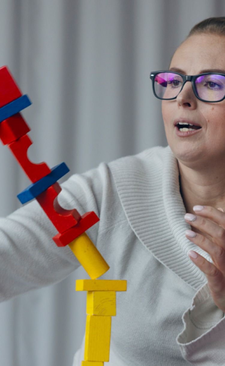 Lastenhoitaja lapsen kanssa leikkimässä