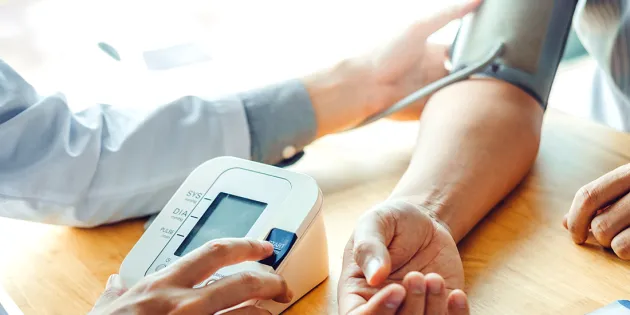 Lääkäri mittaa potilaan verenpaineen.