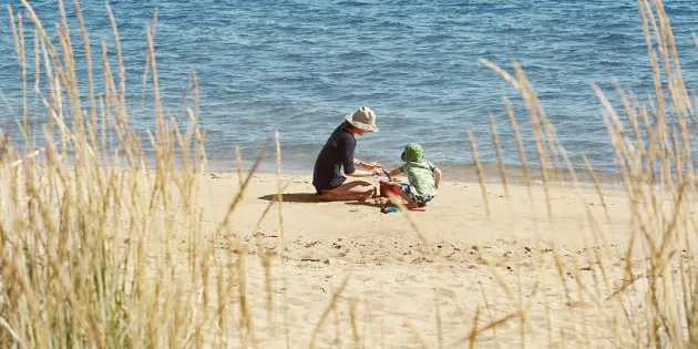 Kuvassa on nainen ja poika rannalla