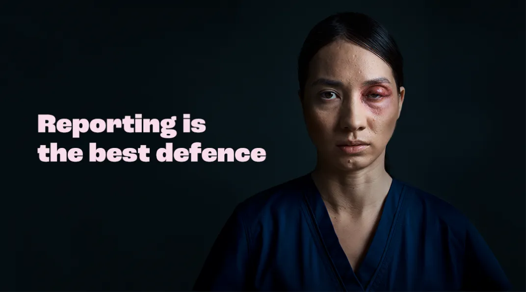 Tummahiuksinen nainen, jolla on musta silmä. Kuvassa teksti "Reporting is the best defence".