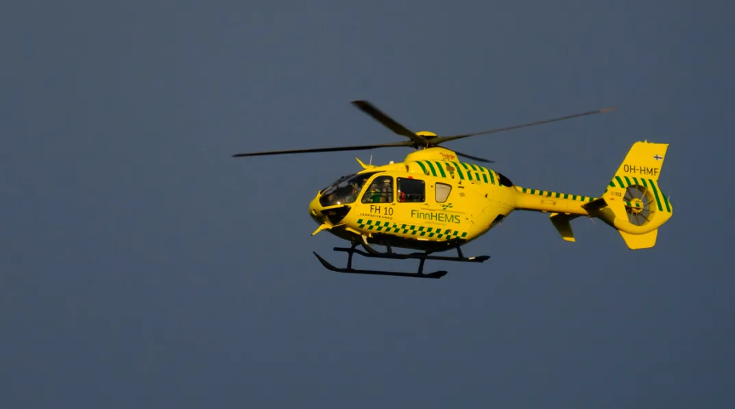 Kuvassa keltainen helikopteri lentää taivaalla.