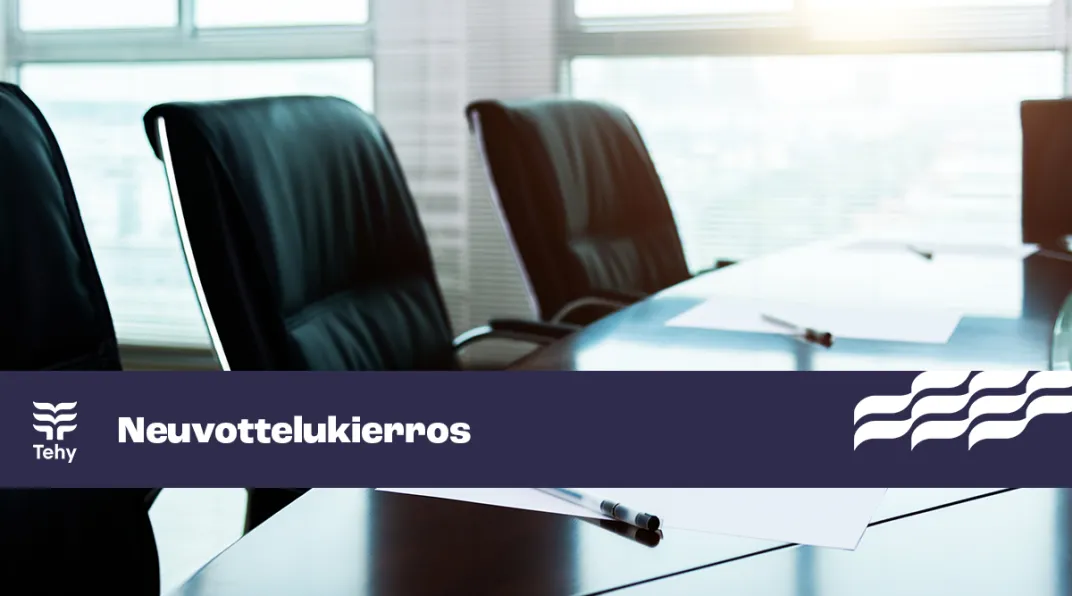 Kokouspöytä. Kuvassa myös sininen nauha, jossa lukee "neuvottelukierros" ja "Tehy".