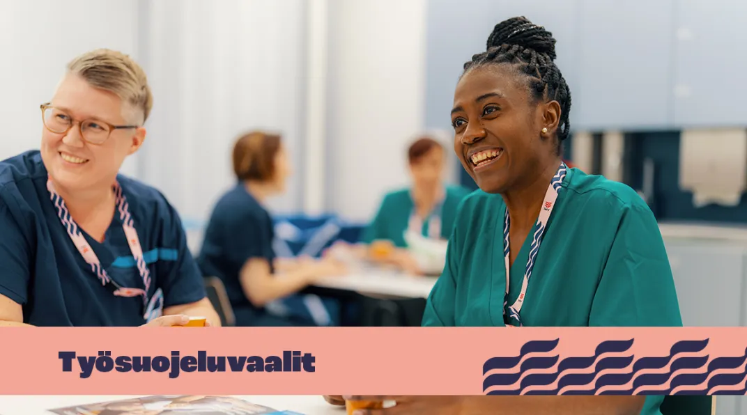 Vaaleatukkainen nainen ja tummaihoinen nainen istuvat ja hymyilevät. Kuvassa on teksti "työsuojeluvaalit".