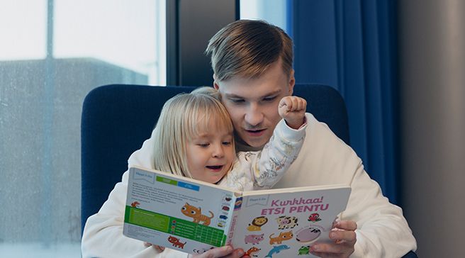 Lastenhoitaja lukee kirjaa lapselle