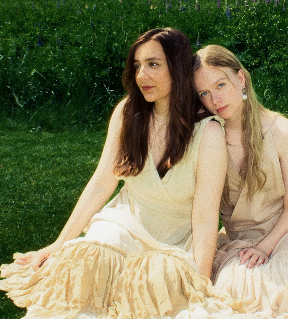 Emma ja Matilda istumassa nurmikolla