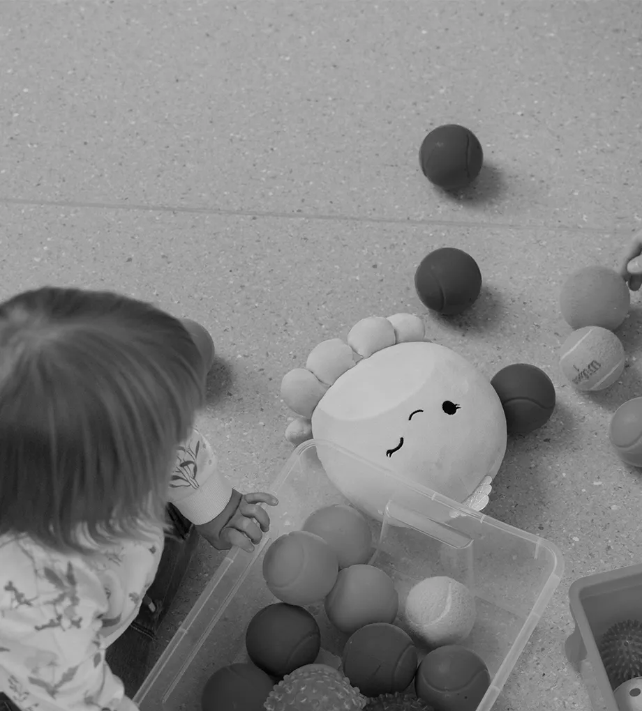 Lapsi leikkii lattialla leluilla