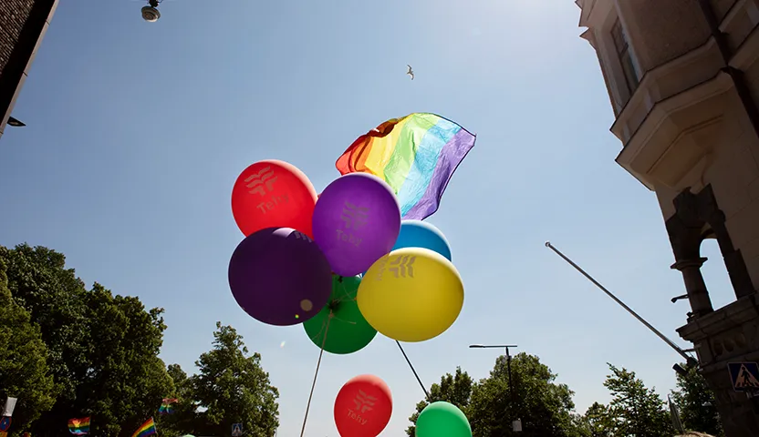 Kuvassa Pride-lippu ja ilmapalloja