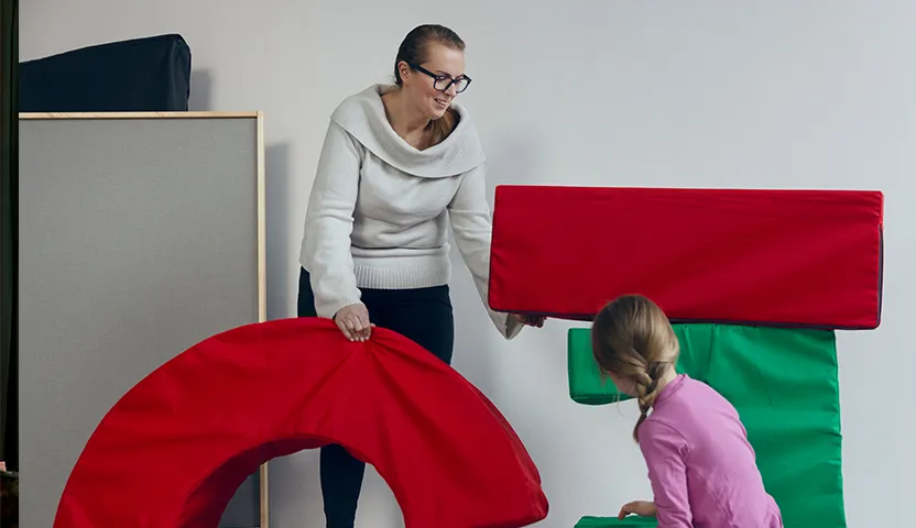 Lastenhoitaja leikkii lapsen kanssa