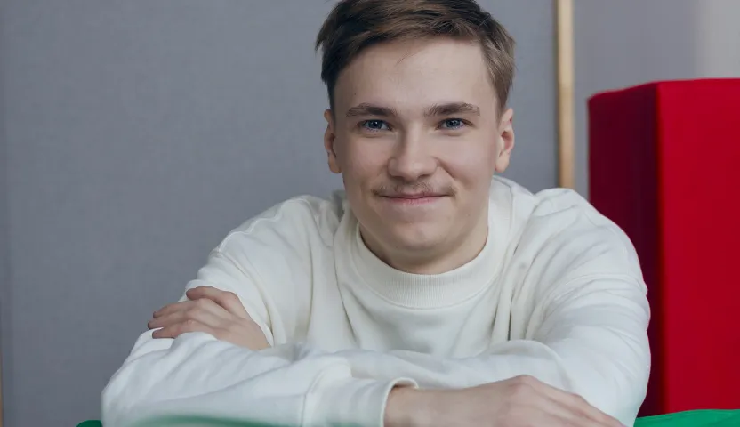 Lastenhoitaja nojaa pehmopalikkaan ja hymyilee