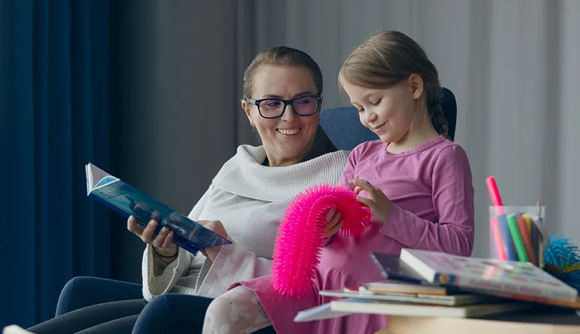Sosiaalialan työntekijä lukee lapselle